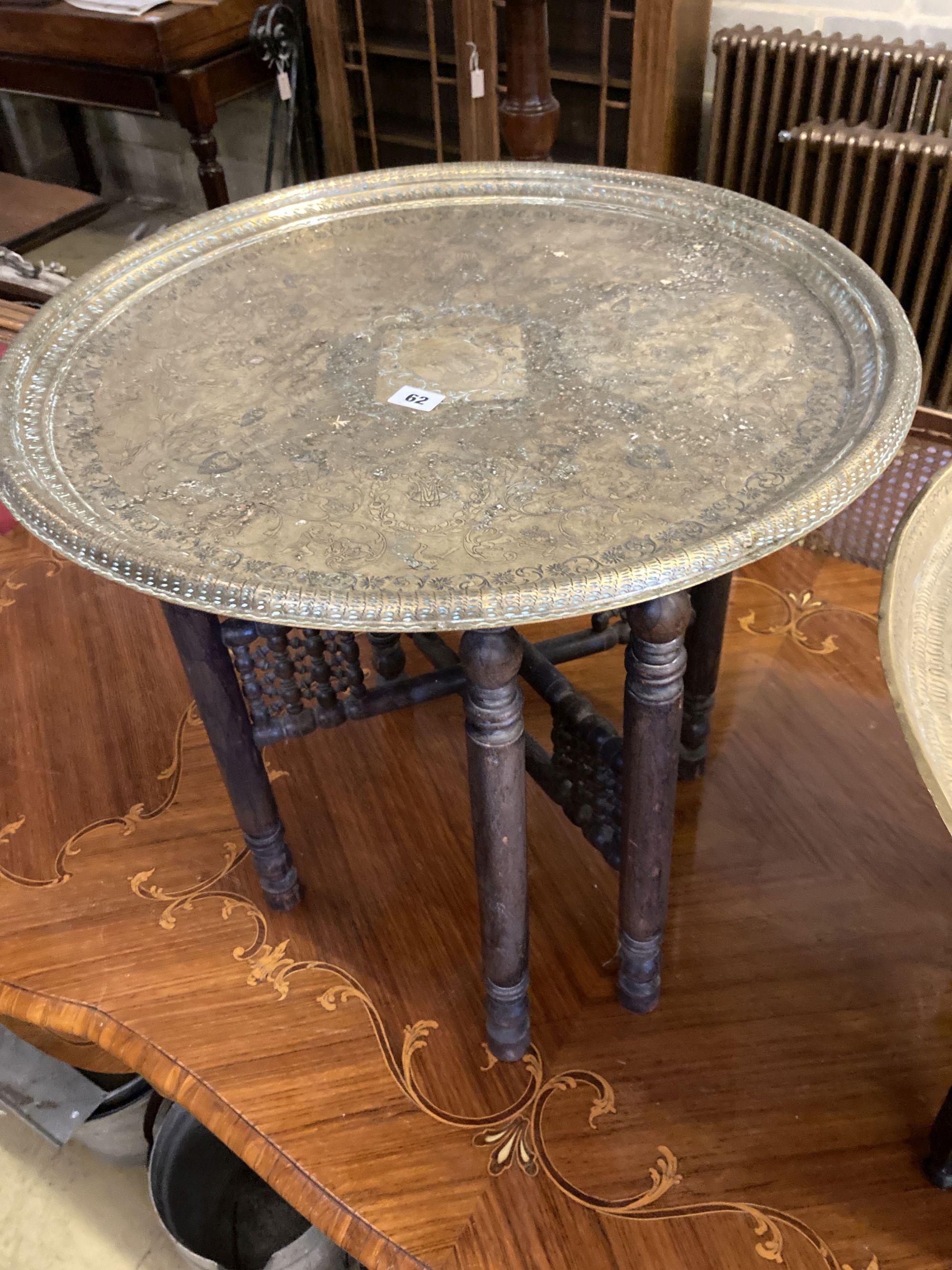 Two Benares engraved circular tray top tables, larger 59cm diameter, 53cm high